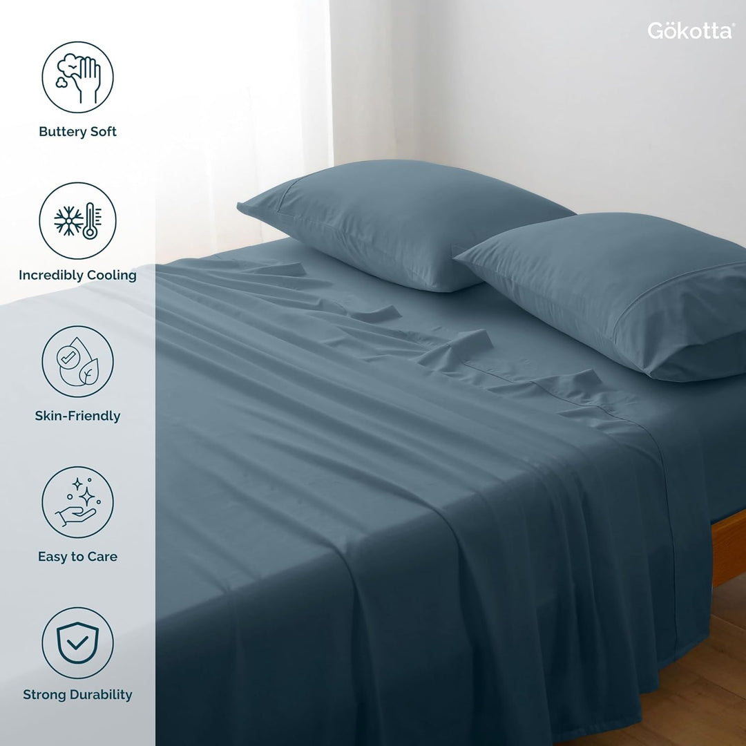 The GOKOTTA sheets laid on a bed, showcasing their combination with other bedding items.