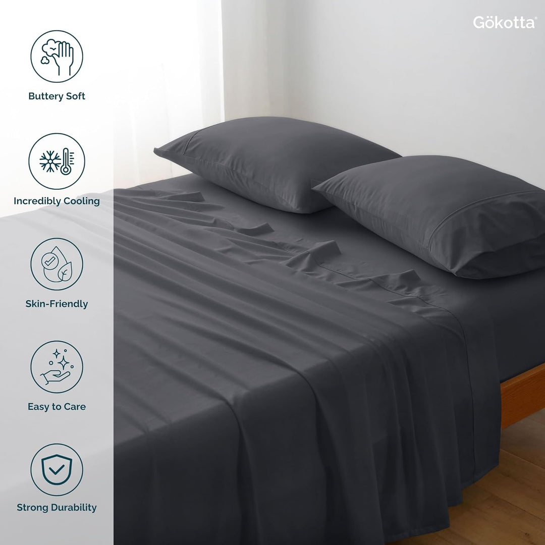 The GOKOTTA dark grey sheets laid on a bed, showcasing their combination with other bedding items.