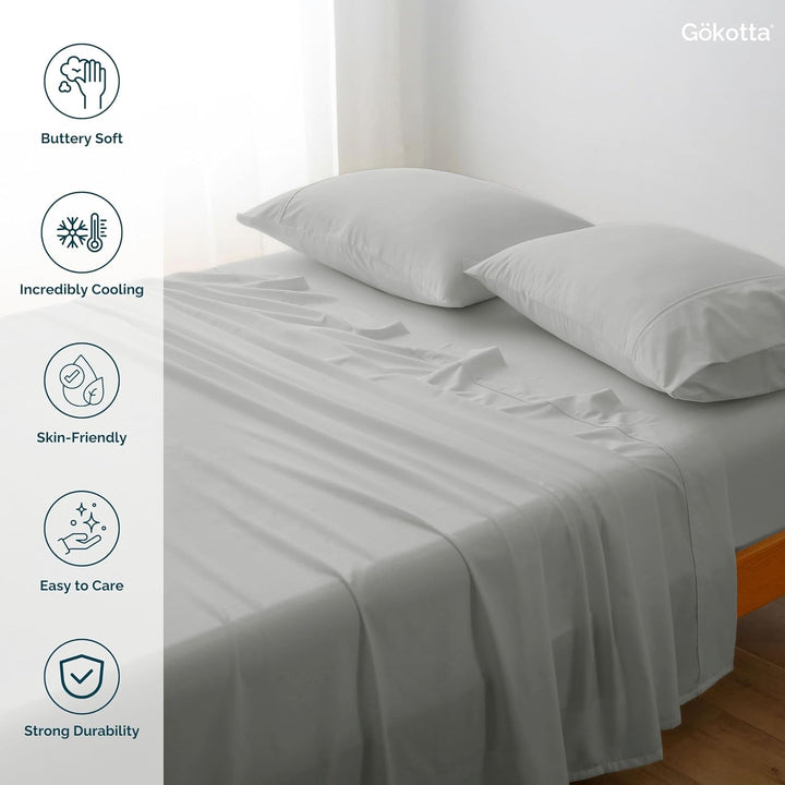 The GOKOTTA grey sheets laid on a bed, showcasing their combination with other bedding items.