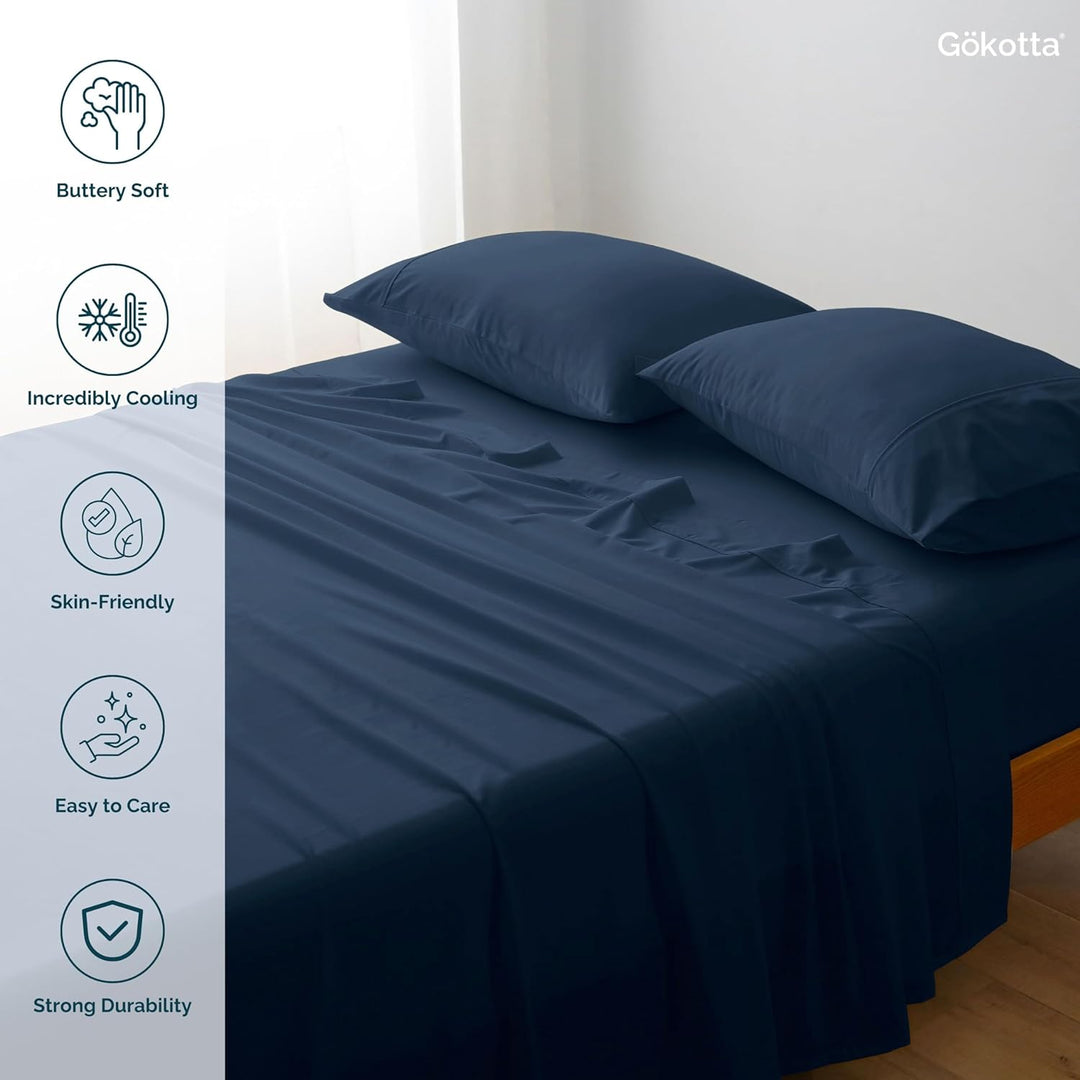 A tidy bedroom scene with GOKOTTA Navy Blue Bamboo Cooling Sheets laid out on the bed. A pillow paired with the sheets, showcasing the overall design aesthetic.