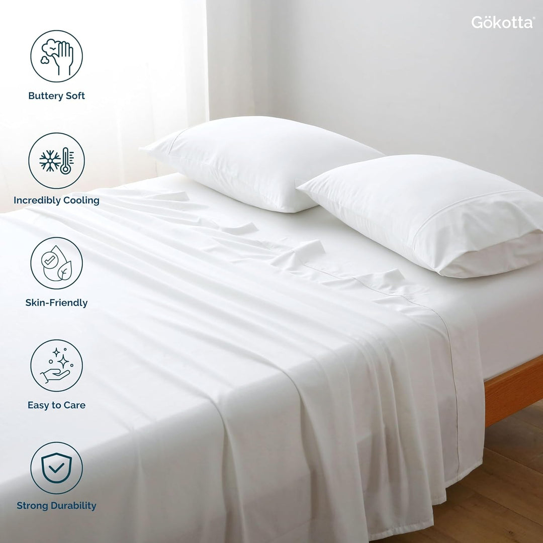 The GOKOTTA sheets laid on a bed, showcasing their combination with other bedding items.