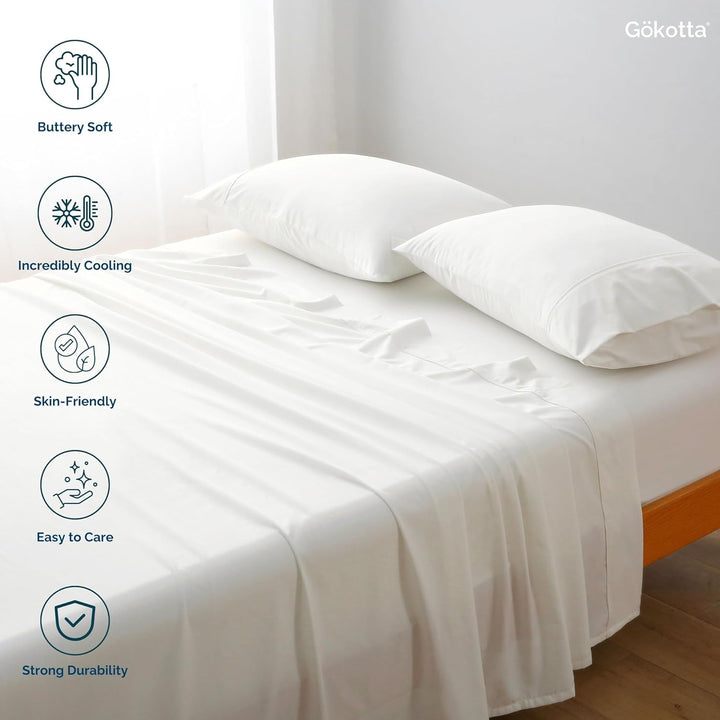 The GOKOTTA sheets laid on a bed, showcasing their combination with other bedding items.