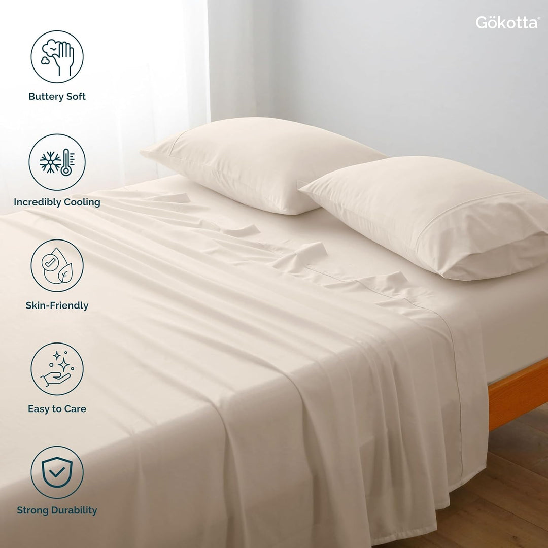 The GOKOTTA sheets laid on a bed, showcasing their combination with other bedding items.